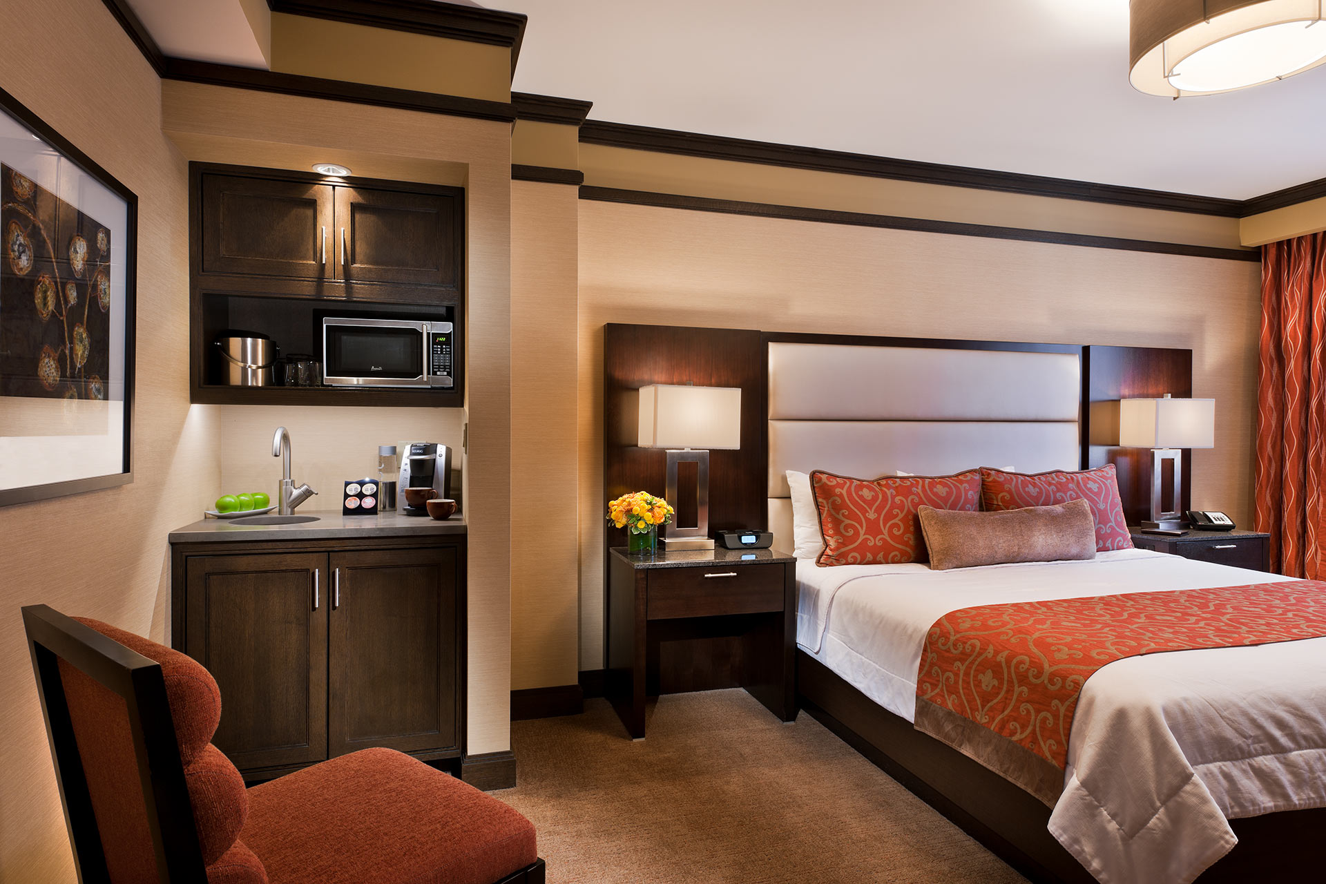 A hotel room with a king-sized bed, a microwave, a sink, and a coffee maker.